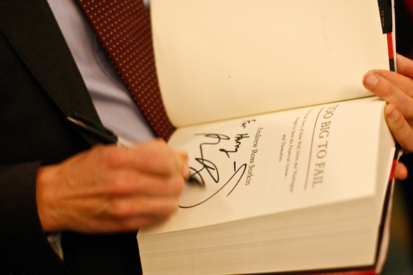 Best-selling author Andrew Ross Sorkin autographs copies of "Too Big to Fail."